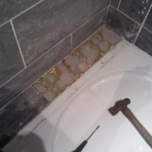 the gap between the wall and shower tray has been filled with expanding foam, then tiled