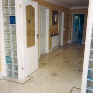 ENTRANCE HALLWAY 'IN' - 300X300MM CREMA MARFIL MARBLE WITH INSETS AND INLAY BORDER IN NOCHE /BLACK TUMBLED MARBLE.