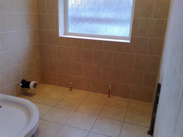Ashford - Tiled floor and walls in bathroom using 12x12 porcelain floor tiles and 12x10 tiles in a brick-bond formation