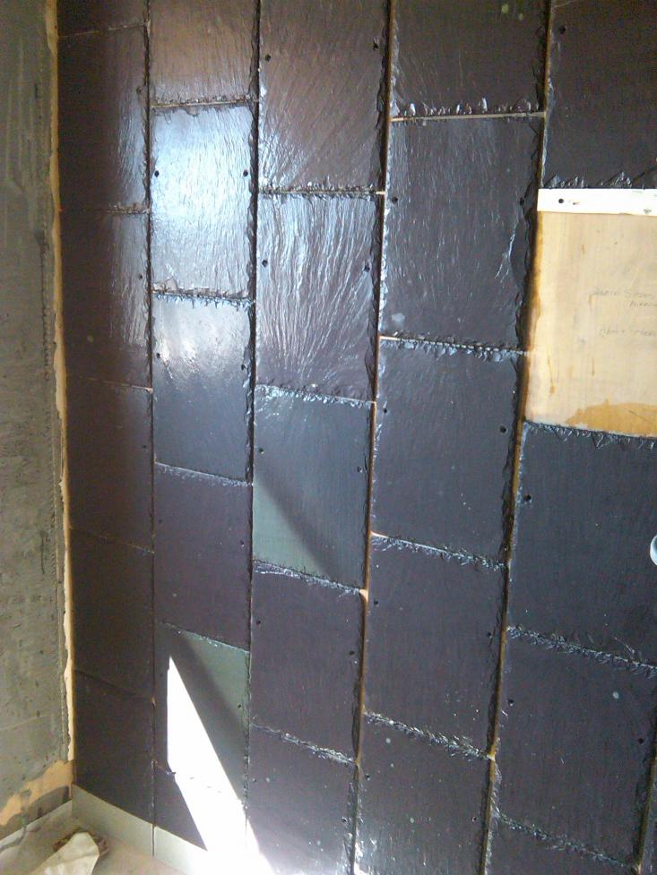 Roof slates fixed to walls - the nail holes came in handy for fixing a temporary tack through to take the weight of the slates whilst the adhesive was setting.